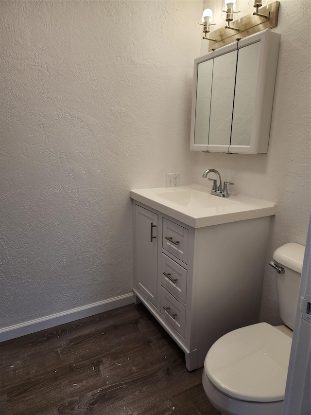 bathroom featuring toilet, hardwood / wood-style flooring, and vanity