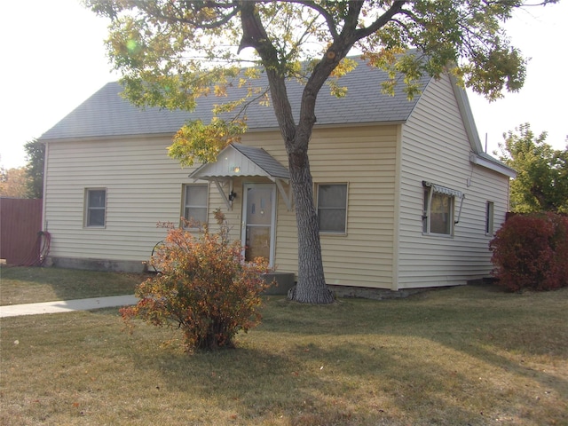 view of front of property with a front lawn and a shingled roof