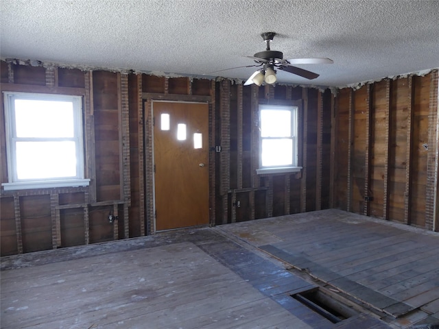 interior space with ceiling fan and a textured ceiling