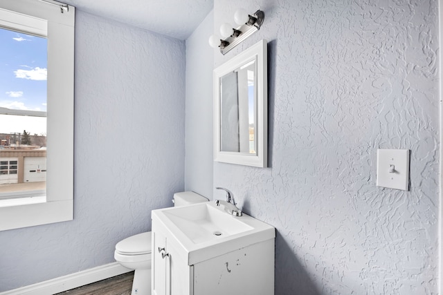 bathroom featuring wood-type flooring, vanity, and toilet