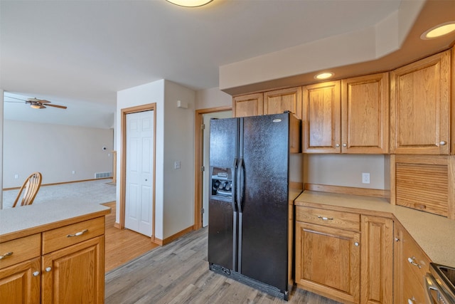 kitchen featuring ceiling fan, light hardwood / wood-style flooring, electric range, and black fridge with ice dispenser