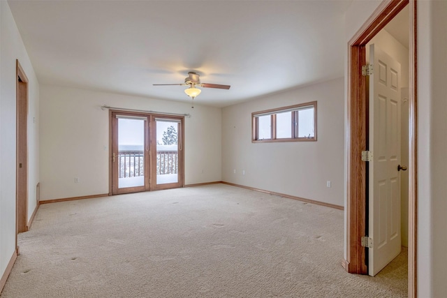 spare room featuring a healthy amount of sunlight, ceiling fan, and light colored carpet