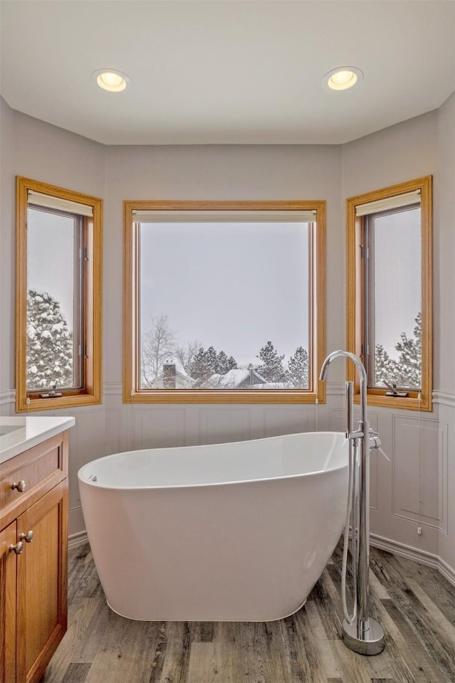 bathroom featuring hardwood / wood-style flooring, vanity, and a bath