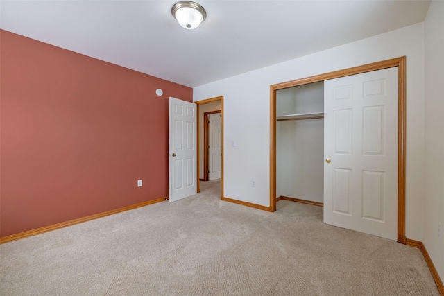 unfurnished bedroom featuring light carpet and a closet