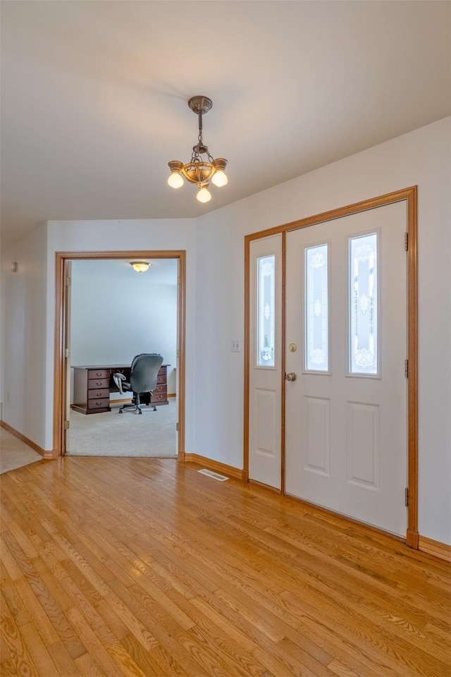 entryway featuring light hardwood / wood-style floors and a chandelier