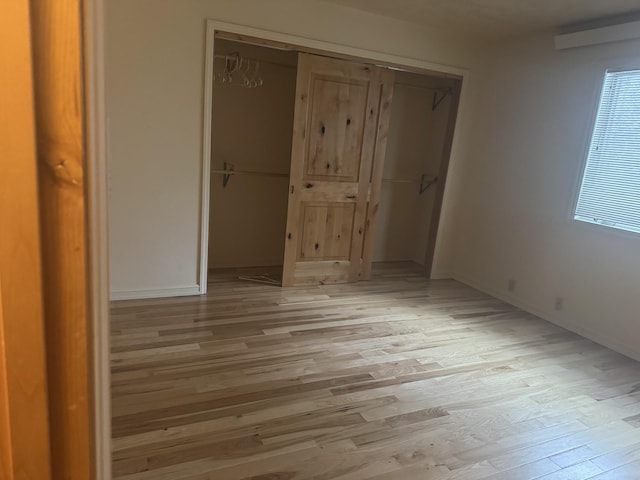 unfurnished bedroom featuring light wood-type flooring and a closet