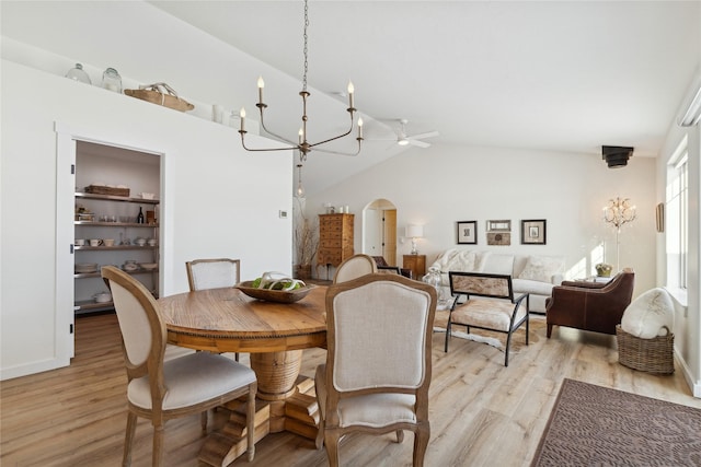 211 Mcwenneger Dr, Kalispell, MT 59901 - dining area featuring a chandelier, arched walkways, light wood-type flooring, and high vaulted ceiling