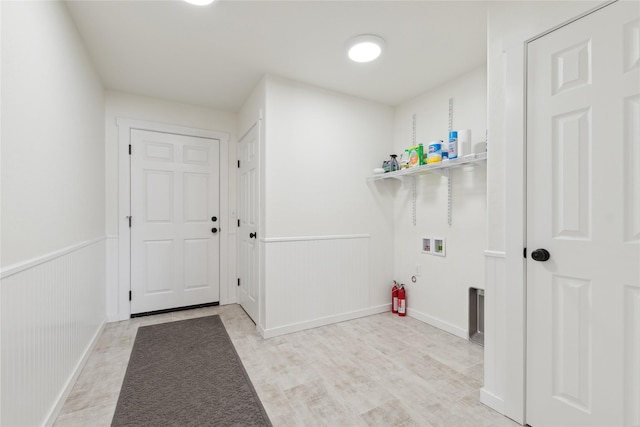 laundry room with washer hookup, laundry area, wainscoting, and light wood-style flooring