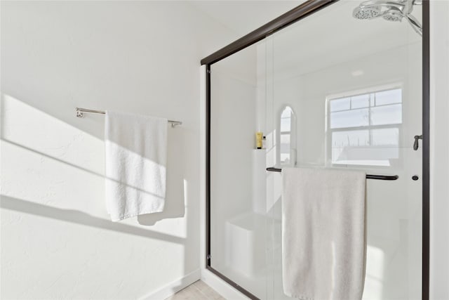 bathroom with a stall shower and baseboards