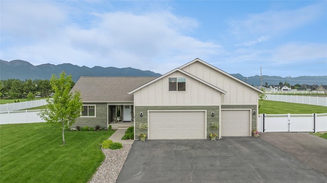 211 Mcwenneger Dr, Kalispell, MT 59901 - view of front of house featuring board and batten siding, a mountain view, driveway, and a garage
