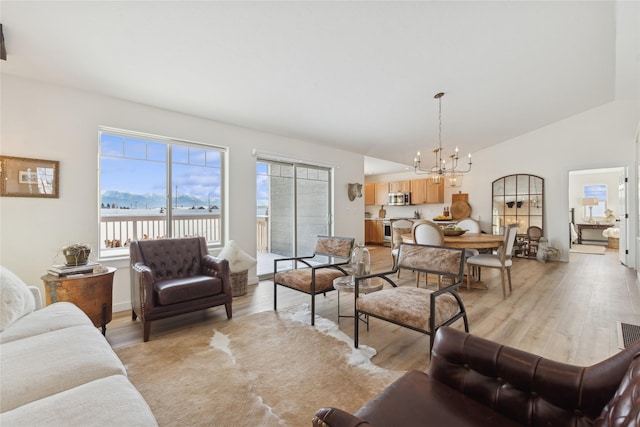 211 Mcwenneger Dr, Kalispell, MT 59901 - living area featuring a chandelier, light wood-type flooring, and vaulted ceiling