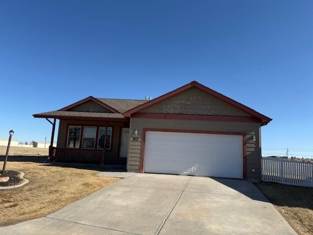 ranch-style home with driveway, an attached garage, and fence