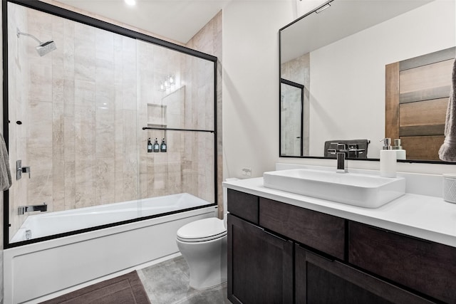 full bathroom with bath / shower combo with glass door, vanity, and toilet