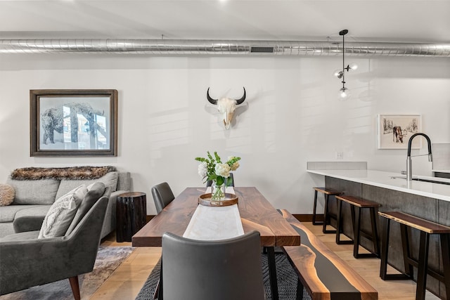 dining area with light hardwood / wood-style flooring and sink