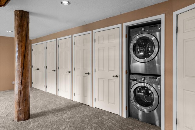21 Barnes Ln, Noxon, MT 59853 - laundry area with a textured ceiling, stacked washer / dryer, and carpet