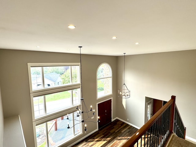 foyer with baseboards, dark wood-type flooring, recessed lighting, and a notable chandelier