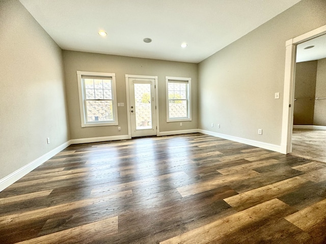 empty room with baseboards, recessed lighting, and dark wood-style flooring