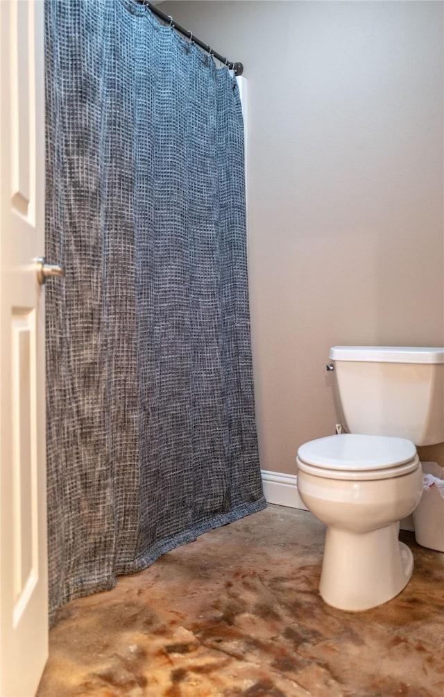 full bath with toilet and baseboards