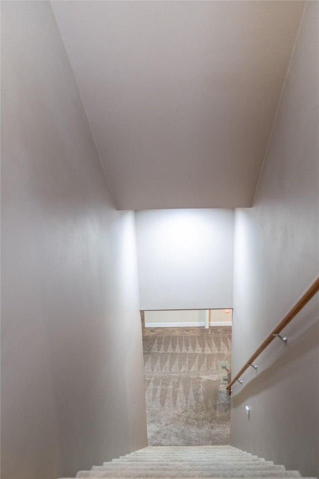 staircase with vaulted ceiling and carpet flooring