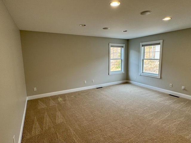 empty room with baseboards, visible vents, recessed lighting, and carpet floors