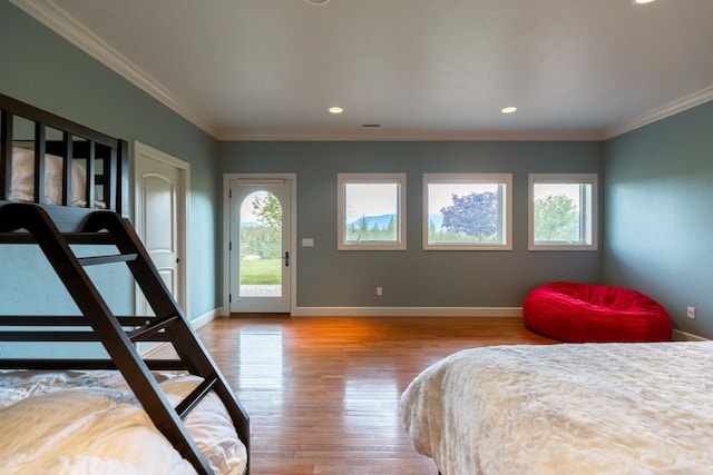 bedroom with baseboards, light wood-style floors, multiple windows, and access to exterior