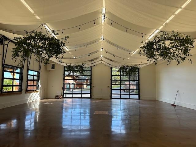 unfurnished room featuring a high ceiling and baseboards