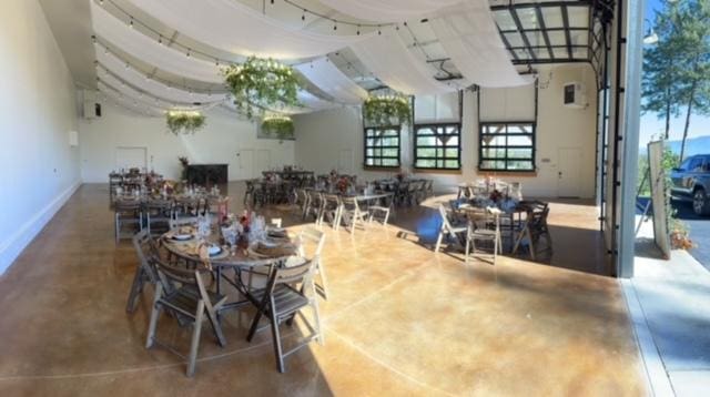 dining area featuring finished concrete flooring, a healthy amount of sunlight, and baseboards