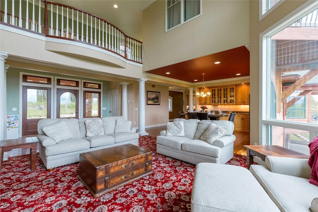 living room featuring ornamental molding, a high ceiling, and ornate columns