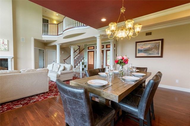 dining space featuring visible vents, baseboards, dark wood-style floors, decorative columns, and crown molding