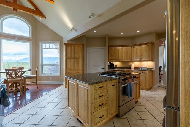 kitchen featuring stainless steel appliances, a kitchen island, dark stone countertops, and light tile patterned floors