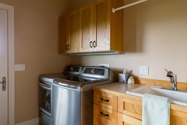 laundry area featuring cabinet space, a sink, and washing machine and clothes dryer