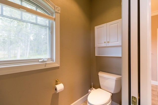 bathroom with baseboards and toilet