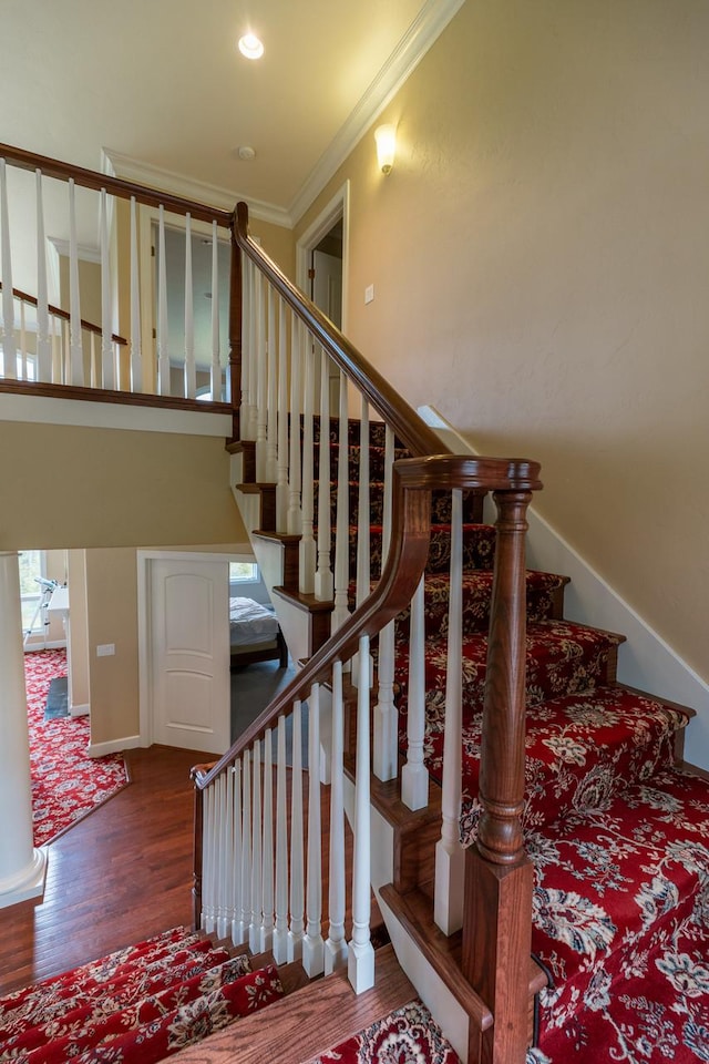 stairway featuring ornamental molding, recessed lighting, baseboards, and wood finished floors