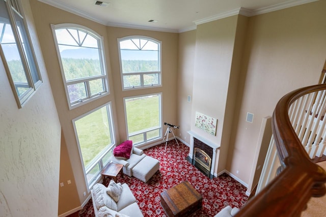 living room with carpet floors, baseboards, stairs, a glass covered fireplace, and crown molding