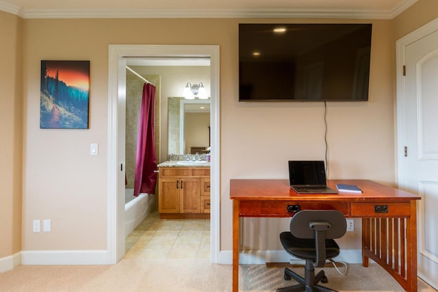 home office featuring light carpet, baseboards, ornamental molding, and a sink