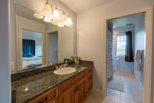 ensuite bathroom featuring a notable chandelier, vanity, ensuite bath, baseboards, and tile patterned floors