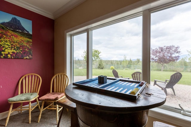 dining space with baseboards and crown molding