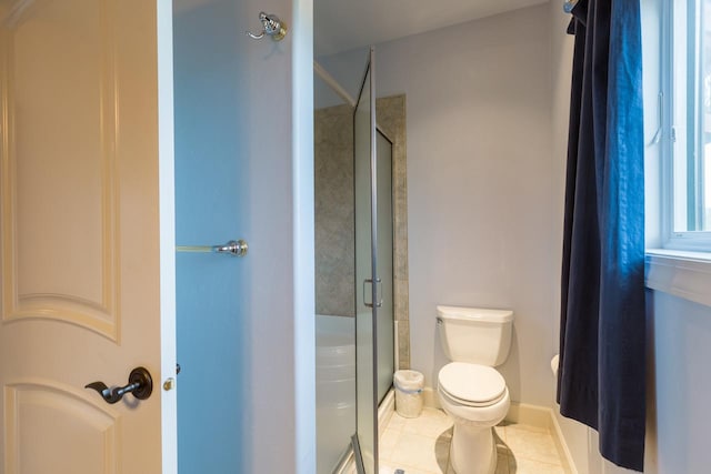 full bath featuring toilet, tile patterned flooring, baseboards, and a shower stall