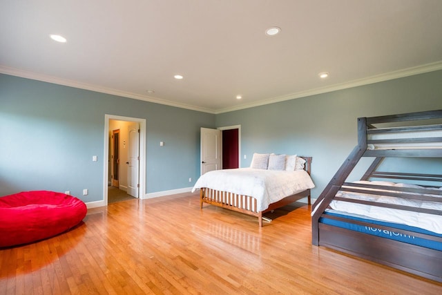 bedroom featuring crown molding, light wood-style flooring, and baseboards