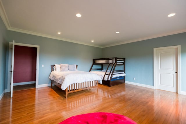 bedroom featuring crown molding, baseboards, wood finished floors, and recessed lighting