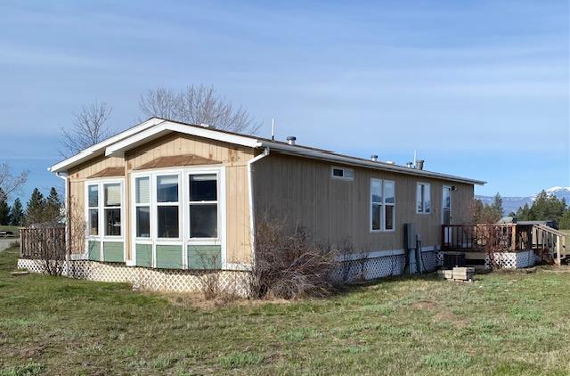 view of home's exterior with a yard and a wooden deck