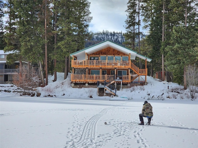 snow covered property featuring stairway and a wooden deck