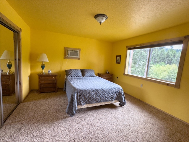 carpeted bedroom with a textured ceiling and a wall mounted AC