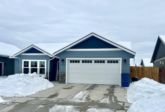 ranch-style home with an attached garage, fence, and concrete driveway