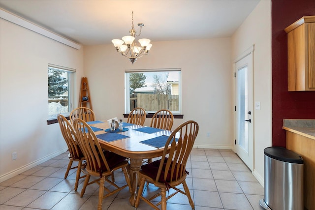 dining area with light tile patterned flooring, baseboards, a notable chandelier, and plenty of natural light