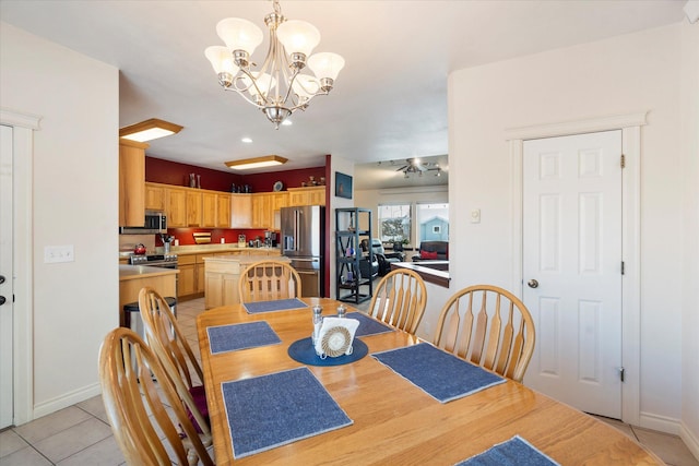 dining room featuring light tile patterned floors, baseboards, and a notable chandelier
