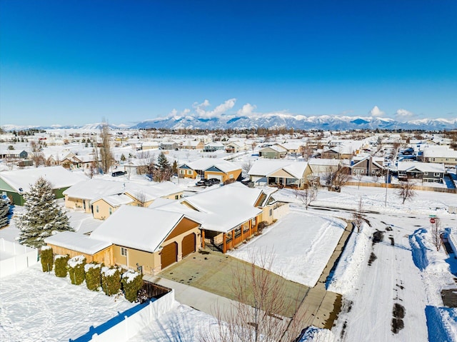 snowy aerial view with a residential view and a mountain view