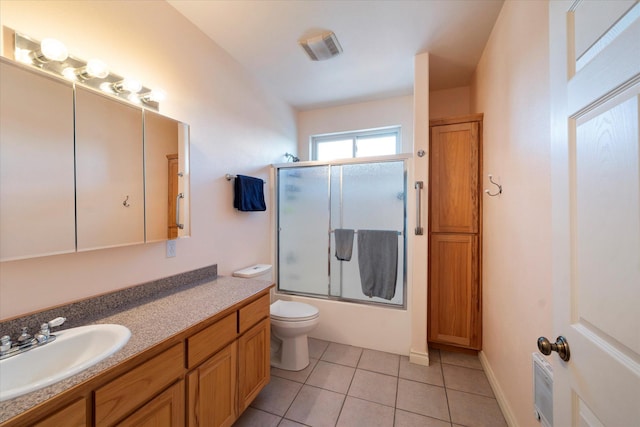 bathroom featuring vanity, visible vents, toilet, tile patterned floors, and enclosed tub / shower combo