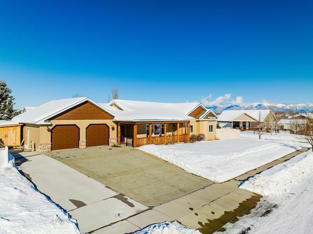 single story home featuring an attached garage, stone siding, a porch, and concrete driveway