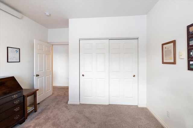 unfurnished bedroom with a closet, carpet, and baseboards
